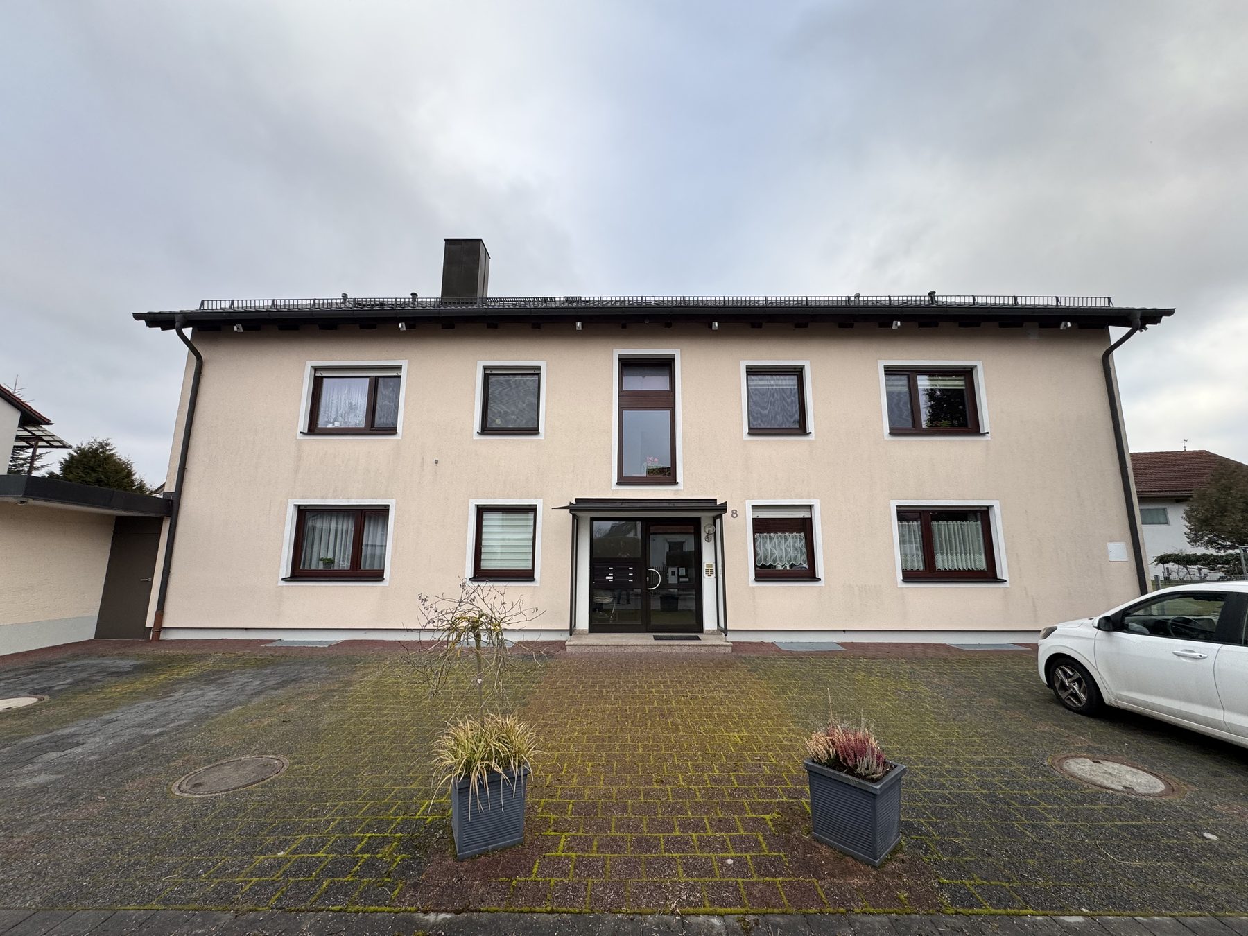 Mehrparteienhaus in Aschheim vor dem Anstrich, beige Fassade